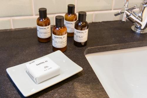 three bottles of alcohol sitting on a counter next to a sink at Das kleine Grindel in Hamburg