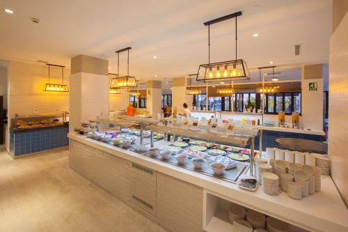a restaurant with a buffet line with food at Corallium Beach by Lopesan Hotels - Adults Only in San Agustin