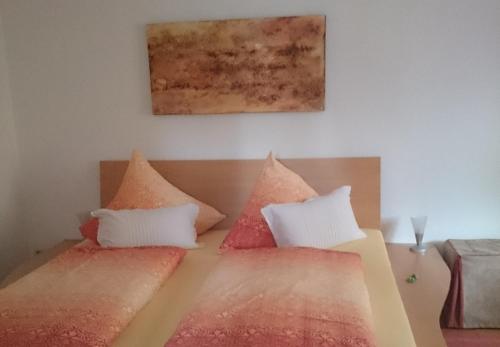 een slaapkamer met 2 bedden met rode en witte kussens bij Haus Schnitzler in Wasserburg