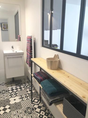 een badkamer met een wastafel en een tafel met handdoeken bij Le 17 Faubourg in Annecy