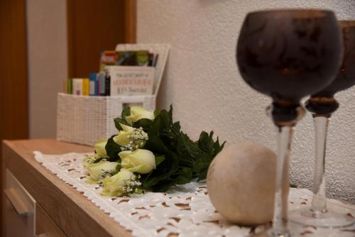 a table with two wine glasses and flowers on it at Pension Heib in Cochem
