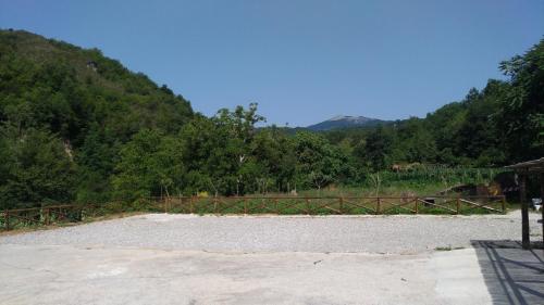 a large field with a wooden fence and trees at Palia's Hotel in Laino Borgo