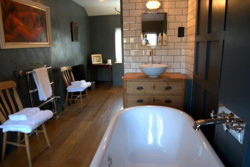 een badkamer met een bad en een wastafel bij Bridge House in Bampton