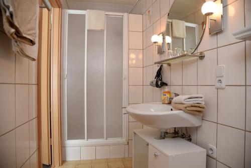 a white bathroom with a sink and a shower at Pension Heib in Cochem