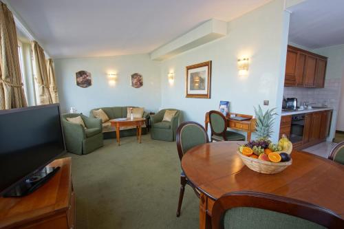 a living room with a table with a bowl of fruit on it at Hotel am Luisenplatz in Potsdam