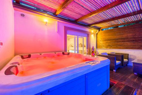bañera grande en una habitación con luces moradas en Alena Luxury apartment with jacuzzi, en Split