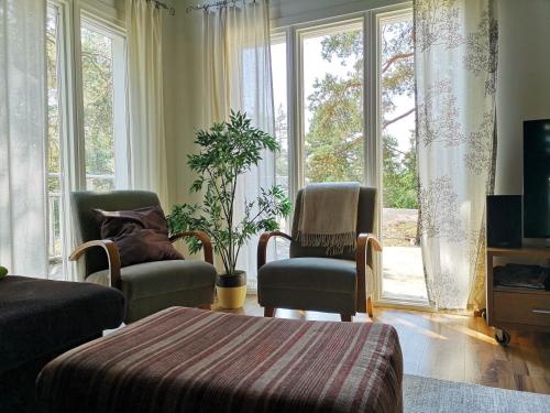 a living room with two chairs and a large window at Mäntykallio in Loviisa