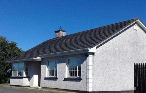 a white house with a chimney on top of it at Relaxing Break at Coshel View in Foyle Bridge