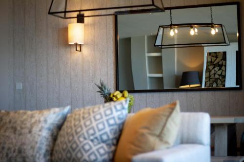 a living room with a couch and a mirror at Carbis Bay and Spa Hotel in St Ives