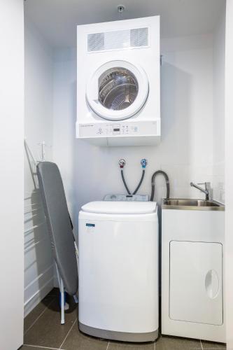a washing machine and a washer and dryer in a room at Boardwalk Burleigh Beach - Official in Gold Coast