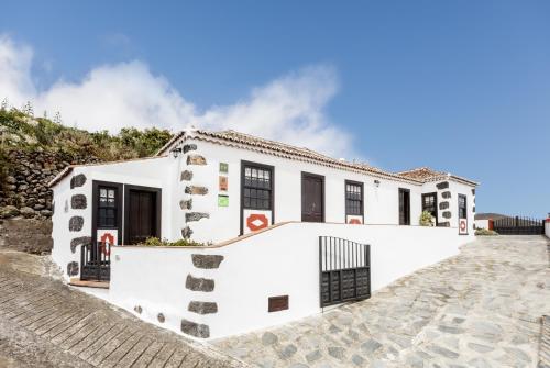 een wit huis met zwarte ramen bij Tomasín in Puntallana