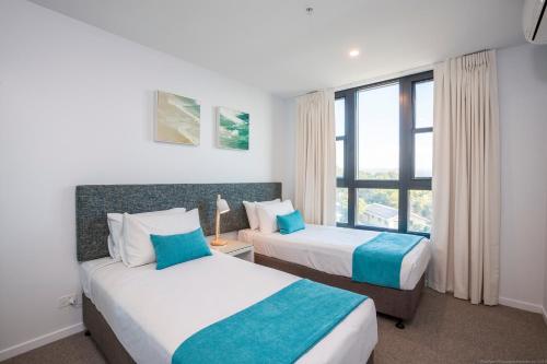 a hotel room with two beds and a window at Boardwalk Burleigh Beach - Official in Gold Coast