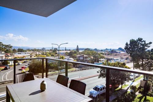 a balcony with a table and a view of a street at Boardwalk Burleigh Beach - Official in Gold Coast