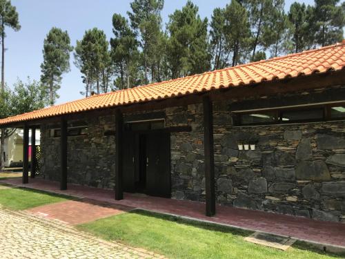 a stone building with a red roof at Camping Oleiros in Oleiros