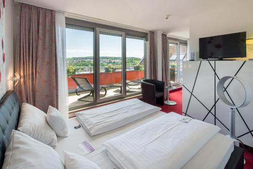 a hotel room with a bed and a large window at Best Western Hotel Am Straßberger Tor in Plauen