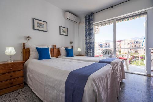 - une chambre avec 2 lits et une grande fenêtre dans l'établissement Apartment Delfín Torrecilla Beach, à Nerja