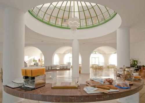 a large room with a glass ceiling and a table with books at Alexandra Beach in Kos Town