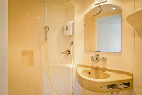W łazience znajduje się umywalka oraz prysznic z lustrem. w obiekcie Première Classe Genève - Aéroport - Prévessin w mieście Prévessin