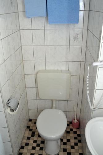 a bathroom with a white toilet and a sink at Hotel An der Karlstadt in Bremerhaven