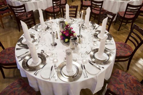 a table with a white table cloth and utensils at Agerskov Kro & Hotel in Agerskov