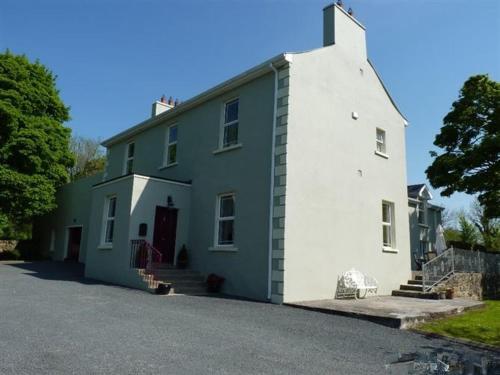 a white and blue house with a driveway at Hartley House B&B in Carrick on Shannon