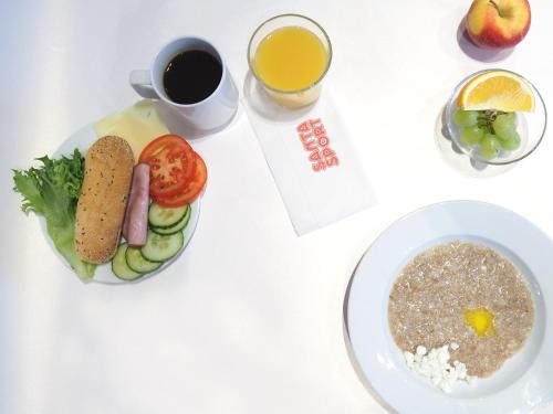 a white table with a plate of food and a cup of coffee at Santasport Resort in Rovaniemi