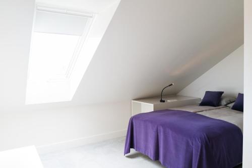 a bedroom with a bed with a purple blanket at Park Hotel Viljandi in Viljandi