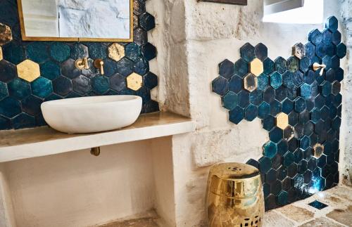 baño con lavabo y azulejos azules en la pared en White Dream, en Ostuni