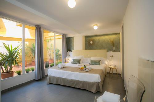 a bedroom with a large bed and a large window at SingularStays Botanico 29 Rooms in Valencia
