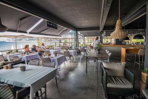 un restaurant avec des tables et des chaises et des personnes y assises dans l'établissement En Vie Beach Boutique Hotel - Adults Only, à Alanya