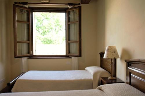 a bedroom with two beds and a window at Agriturismo Il Beccafico Alpaca in Mengara