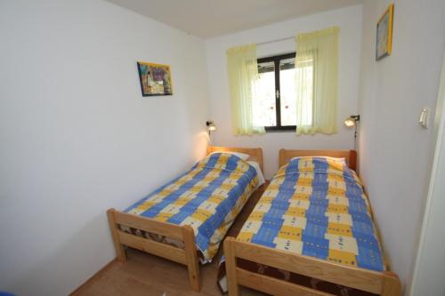 a bedroom with two beds and a window at Kuća za odmor- Simona in Punta Križa
