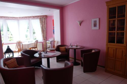 a restaurant with two tables and chairs in a room at Bertricher Hof Hotel Garni in Bad Bertrich