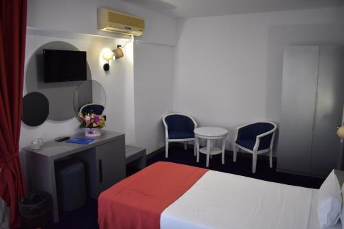 a hotel room with a bed and two chairs at Hotel Europolis in Tulcea