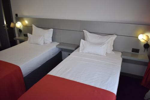 two beds sitting next to each other in a room at Hotel Europolis in Tulcea