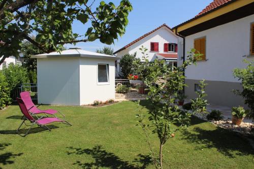 einen rosa Stuhl im Hof eines Hauses in der Unterkunft Schlicht & einfach Traumhaft in Unterkulm