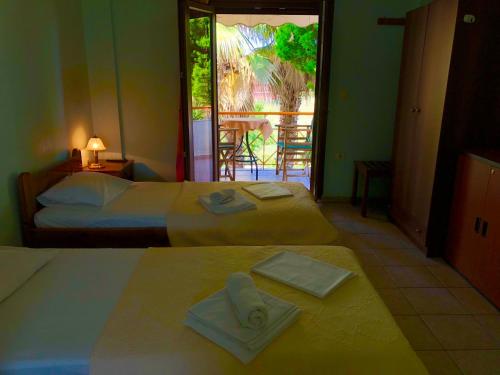 two beds in a room with two towels on them at Ionos in Pyrgi Thermis