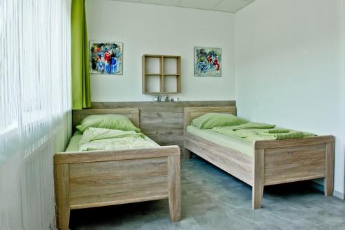 リンツにあるPension Waldesruhのツインベッド2台 緑色のアクセントが施された客室です。
