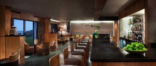 a bar in a restaurant with a bunch of chairs at Bedruthan Hotel & Spa in Newquay