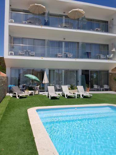 un hotel con piscina frente a un edificio en Casa Praia Mar en Salema