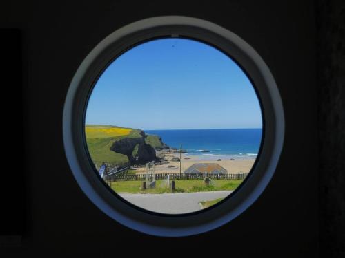 a round window with a view of the beach at Bedruthan Hotel & Spa in Newquay