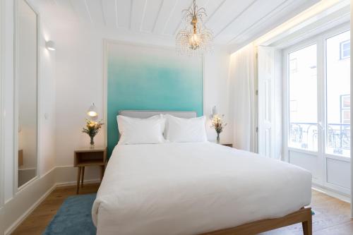 a bedroom with a large bed and a large window at Boutique Chiado Suites in Lisbon
