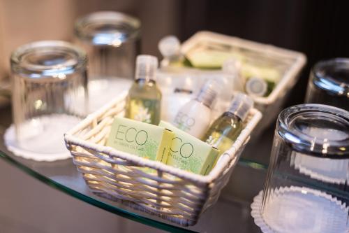 a glass table with a basket with bottles on it at Donauhof - Hotel garni in Weissenkirchen in der Wachau