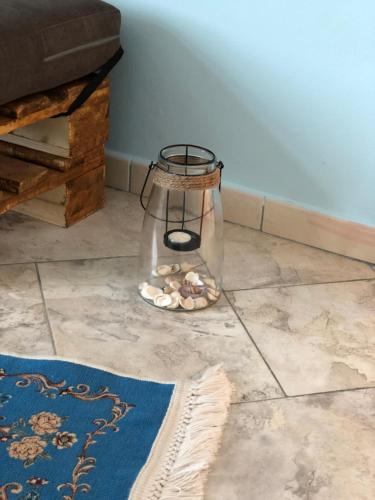 um vaso de vidro com conchas no chão em Casa Natali em Durrës