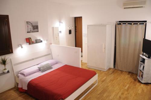una camera con un letto con una coperta rossa di Argo's Apartment a Palermo