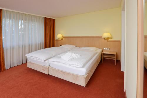 a bedroom with a large white bed in a room at Hotel Sonne Eintracht Achern in Achern