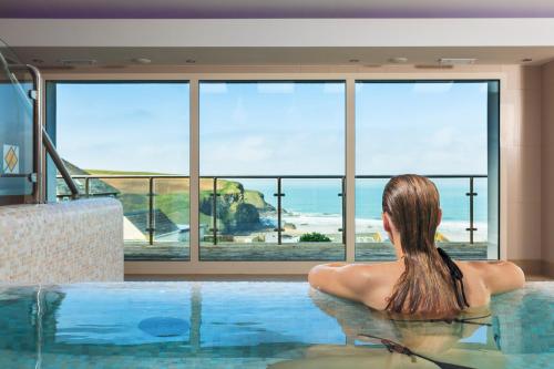 
a woman in a bikini sitting in a swimming pool at Bedruthan Hotel & Spa in Newquay

