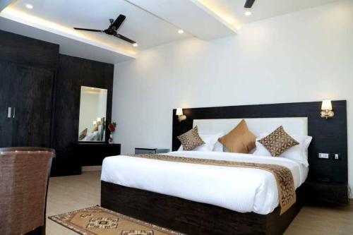 勒克瑙Hotel Vinayak Lifestyle Hotels的卧室设有一张白色大床和天花板