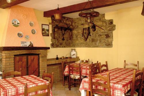 a dining room with two tables and a fireplace at Foresteria La Ceriola in Monte Isola