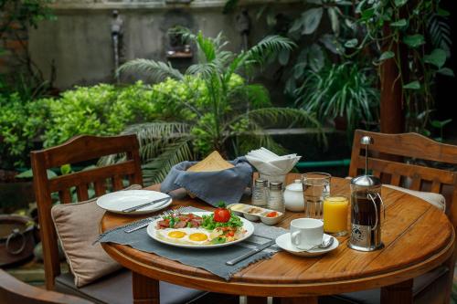a wooden table with a plate of food on it at Ambassador Garden Home in Kathmandu